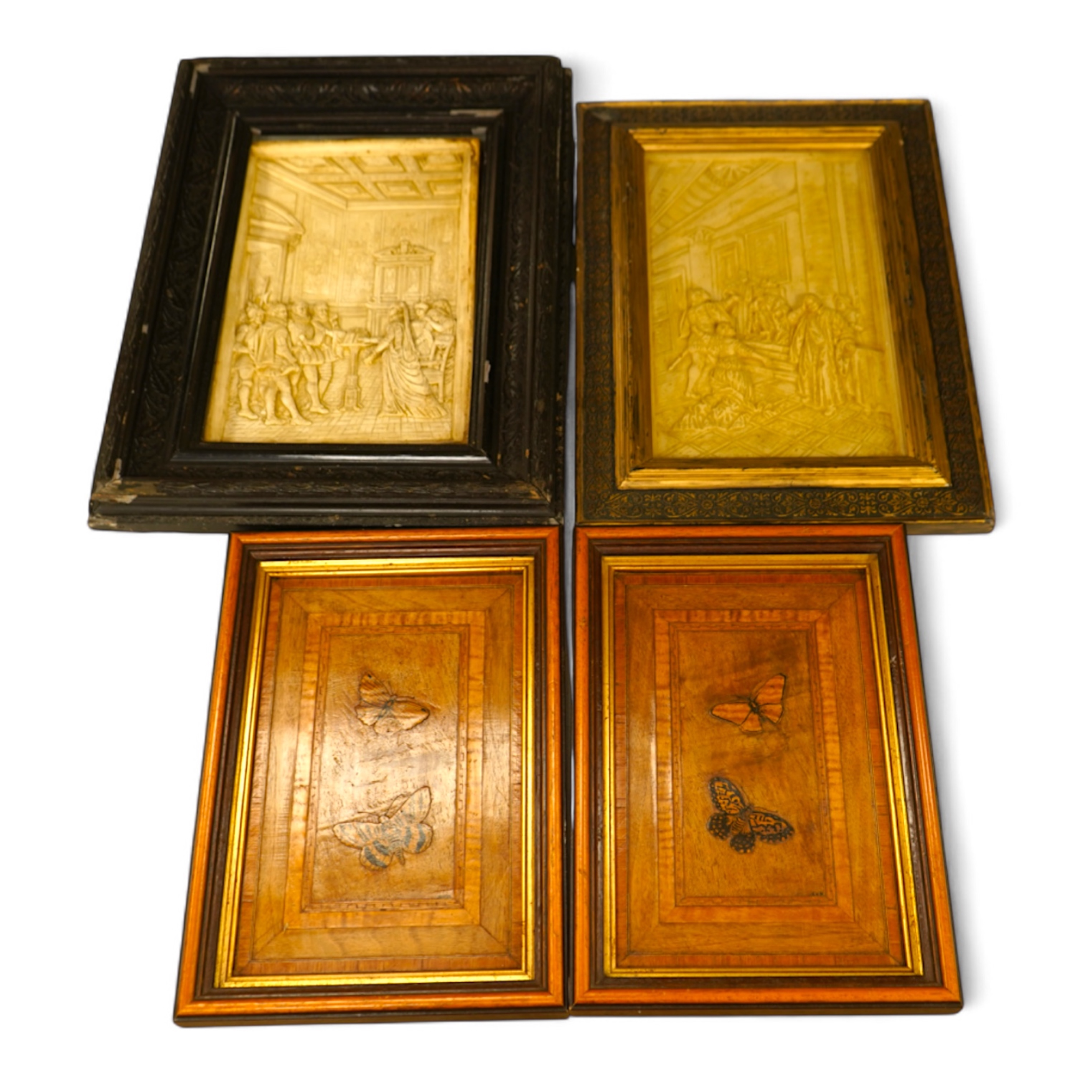 SVD., a pair of marquetry and penwork butterfly panels and a pair of relief moulded plaster panels depicting Tudor scenes, each framed, largest 41cm high